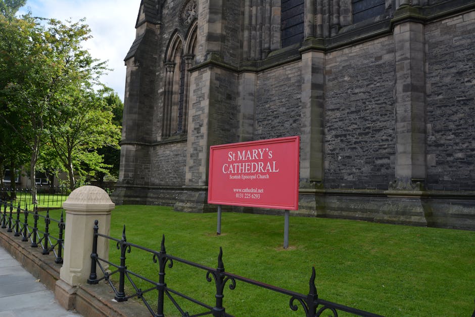 The exterior of St Mary’s Cathedral, a large historic stone church, features detailed Gothic architectural elements such as pointed arches and decorative buttresses. In the foreground, a small, well-m